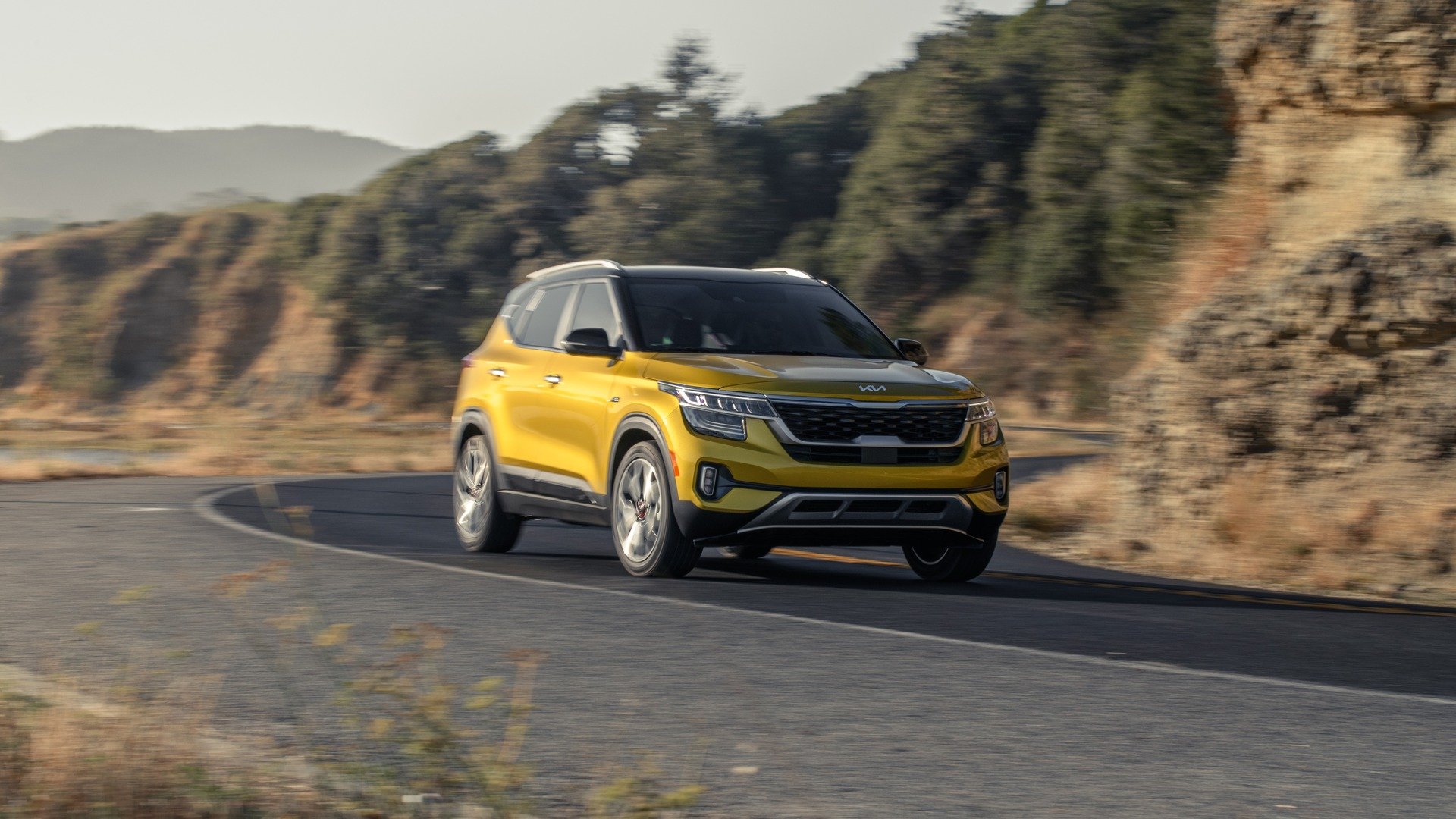 Yellow 2022 Kia Seltos driving on a winding road