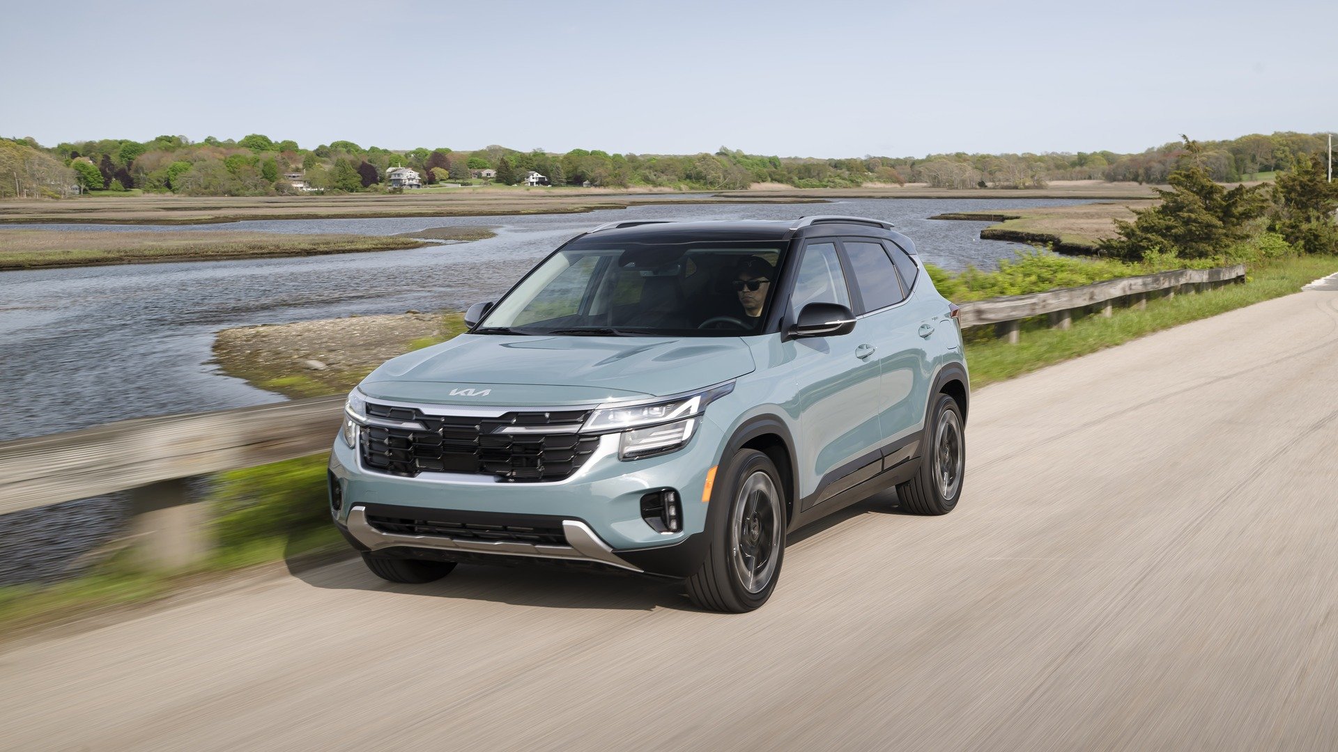 Pluton Blue 2024 Kia Seltos driving by the water