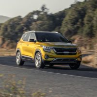 Yellow 2022 Kia Seltos driving on a winding road