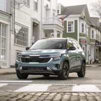 Pluton Blue 2024 Kia Seltos seen head-on on a residential street