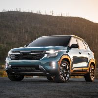 Blue 2025 Kia Seltos seen from the front three-quarter in front of hills